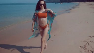 Tropik sahilde güzel kız / güzel kız bikini ve renkli plaj kapağı - ağır çekimde video tropik sahilde güneşte yaz tatili sırasında rahatlatıcı kadar
