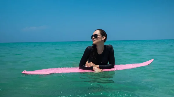 Молодая Счастливая Женщина Купальнике Солнечных Очках Отдыхает Розовой Доске Серфинга — стоковое фото