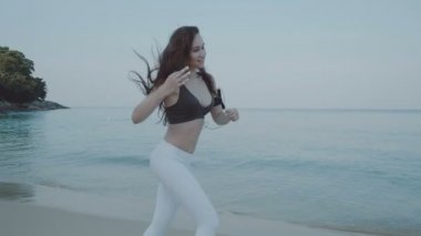 Güzel kız koşu kum plajındaki / güzel genç kız - ağır çekimde video kum plajındaki sabah koşu