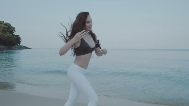 美丽的女孩在沙滩上慢跑 美丽的女孩在早晨慢跑在沙滩上慢动作视频 — 图库视频影像