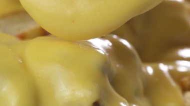 Peynir kıyma et ve fasulye soslu patates kızartması üstüne / makro closeup Şef peynirli patates kızartması üstüne koyarak cips soslu biber con carne - ağır çekim video