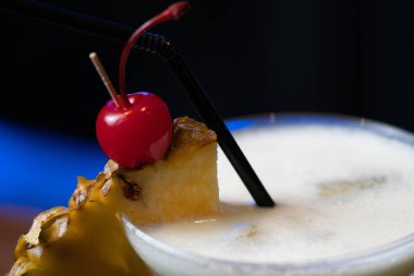 Kokteyl veya ananas dilim ve kiraz bardaki saman ile süslenmiş yumruk