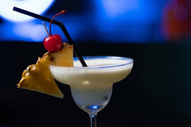 Kokteyl veya ananas dilim ve kiraz bardaki saman ile süslenmiş yumruk