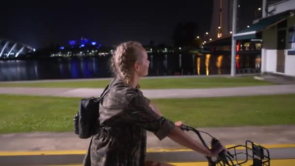 夜街を自転車乗りを楽しんで夜 魅力的な幸せな女で彼女の自転車に乗って幸せな女 — ストック動画