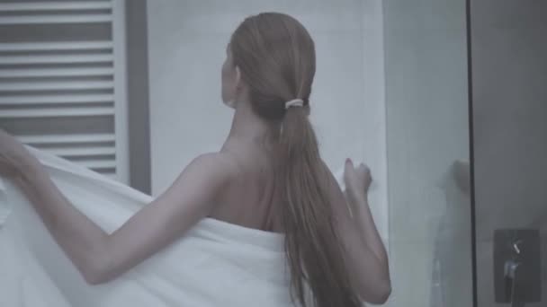 女人在她的公寓 漂亮的女人走到卫生间把毛巾放在赤裸的身体上 — 图库视频影像