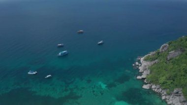 Tayland 'daki güzel Koh Tao adası yakınlarındaki teknelerle göl suyu yüzeyinin hava aracı görüntüsü.