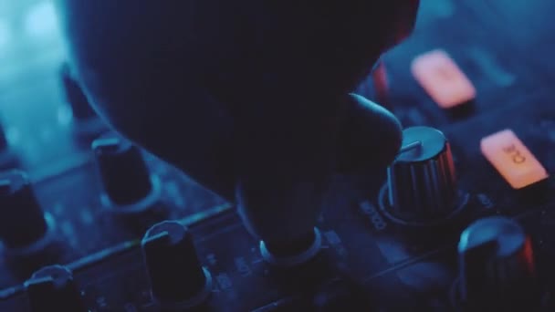 Boucle boomerang avant et arrière main rapprochée de l'homme DJ tournant bouton sur la console de mixage sonore dans la boîte de nuit 