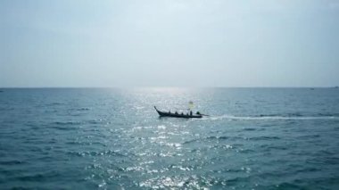 Güneşli yaz gününde, turkuaz açık denizde geleneksel ahşap uzun kuyruklu teknenin hava aracı görüntüsü.