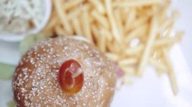 Patates kızartması ve lahana salatalı en iyi hamburger manzarası. Ağır çekimde video.