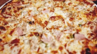 Restoranda yeni pişmiş süper pizzanın yakın çekimi. Yavaş çekimde video.