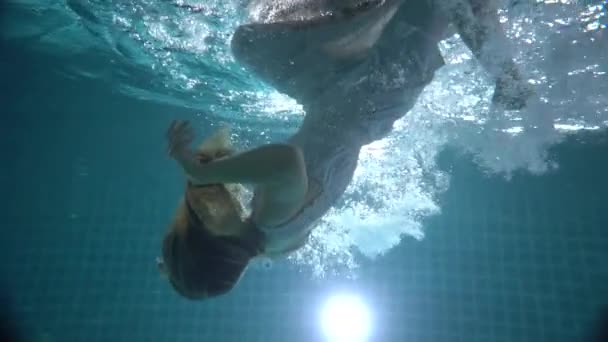 長い赤い髪の美しい女性がドレスで水中で泳いで ビデオをスローモーションで — ストック動画