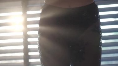 Siyah dantelli pantolon giyen, pencerenin üzerinde dans eden, arka planda perdelerle dans eden seksi kadının yakın çekim bacakları. Yavaş çekimde video.