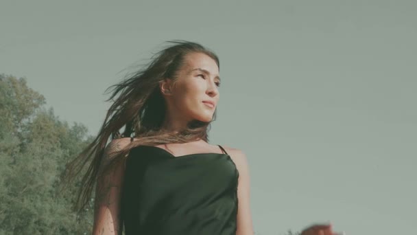 美丽的黑发女子 身穿黑色丝质衣服 夏天在海滩边散步 与摄像机调情 慢镜头 — 图库视频影像