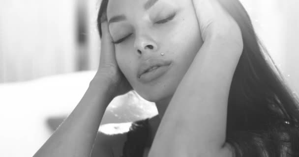美しさの肖像画ブルネット女性で黒ランジェリーポージングオンザベッド 黒と白のビデオでスローモーション — ストック動画