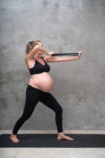 ジムで抵抗バンドとかなり妊娠中の女性の練習の肖像画 運動とフィットネス 妊娠の概念 — ストック写真