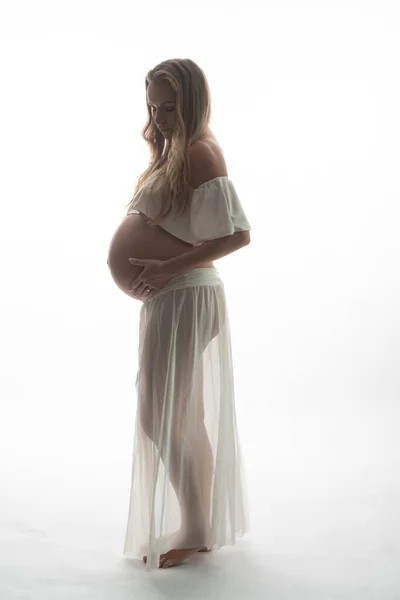 Беременная Женщина Трогает Живот Стоя Белом Фоне Концепция Материнства — стоковое фото