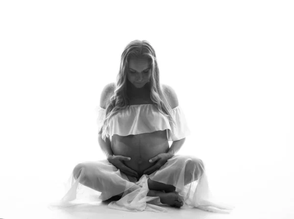 Mujer Bastante Embarazada Tocándose Vientre Mientras Está Sentada Sobre Fondo —  Fotos de Stock