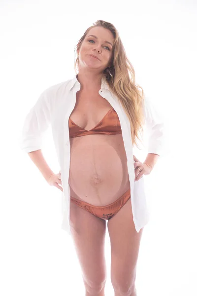 ランジェリー姿で白い背景の上に立つ可愛い妊婦さん 産前概念 — ストック写真