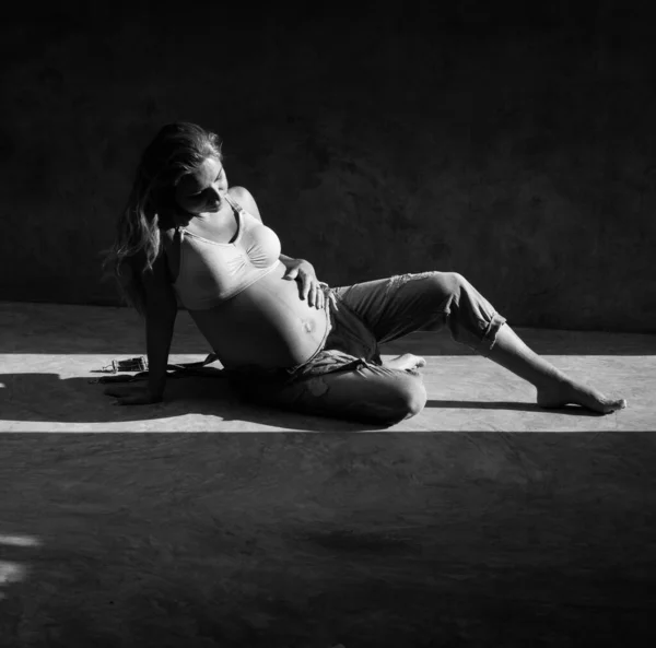 Hübsche Schwangere Jeans Jumpsuit Und Sitzt Sonnenlicht Auf Dem Betonboden — Stockfoto
