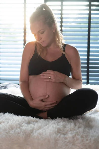 Ganska Gravid Kvinna Svarta Leggins Och Behå Håller Hennes Mage — Stockfoto