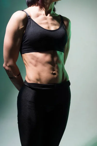 Slim woman belly against a light background.