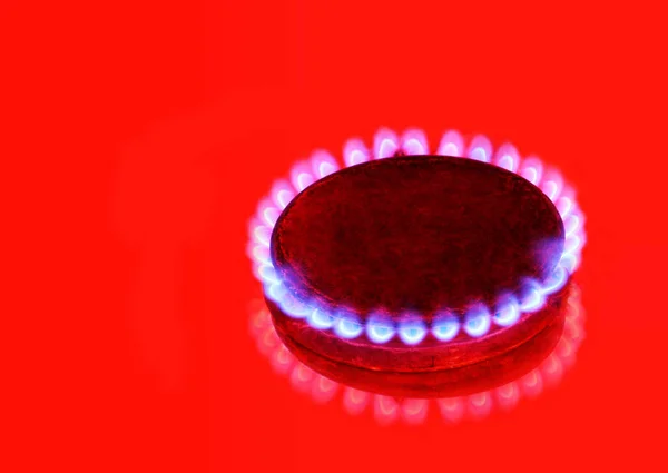 Burning gas ring on red background.