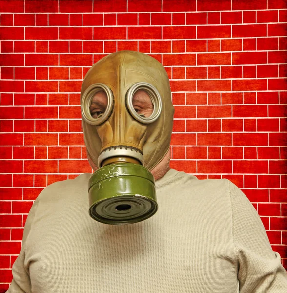 Män i gas mask tas närbild på grunge rött tegel bakgrund — Stockfoto