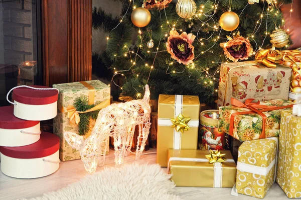 Altın Noel hediyeleri ve Noel ağacının yakınındaki geyik alındı. — Stok fotoğraf