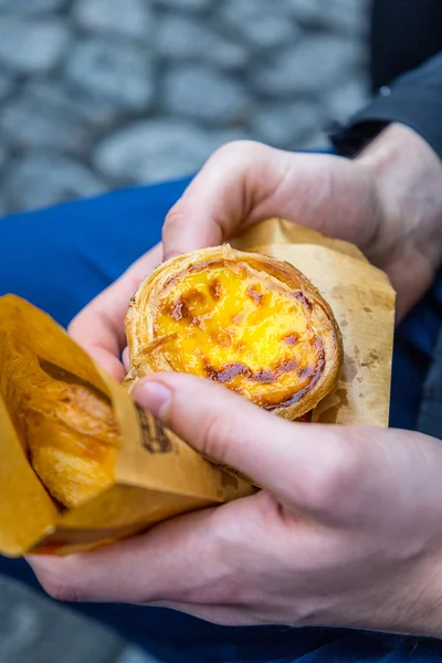 Португальский десертный яичный пирог (Pasteis de Nata) в руке человека, крупным планом — стоковое фото