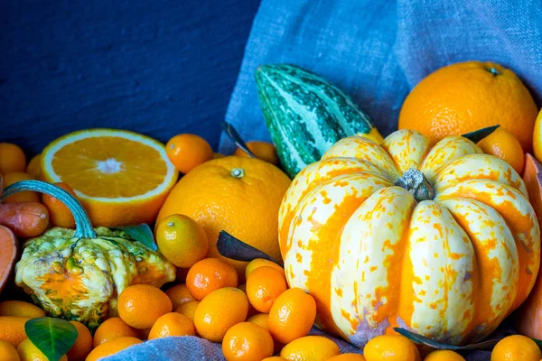 Pompoenen, Kumquats, sinaasappelen, zoete aardappelen en wortelen op donkere houten achtergrond, herfst Wallpaper — Stockfoto
