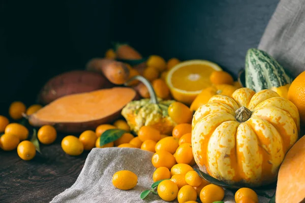 Pompoenen, Kumquats, Orange, zoete aardappel op donkere houten achtergrond, gefilterde afbeelding — Stockfoto