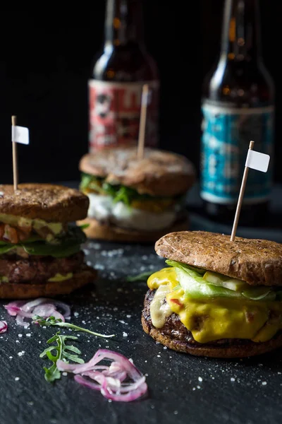 Three Different Tasty Big Burgers on Dark Stone Background — Stock Photo, Image