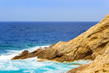 Dalgalar üzerinde kayalık sahil kır. Bali, Crete