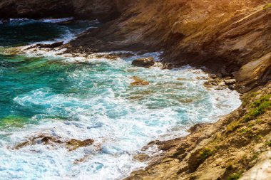 Dalgalar üzerinde kayalık sahil kır. Bali, Crete