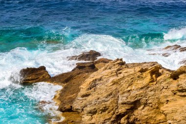 Dalgalar üzerinde kayalık sahil kır. Bali, Crete