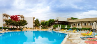 Bali, Yunanistan - 2 Mayıs 2016: Otelde öğle anda turist olmadan boş havuza. Sakin ol ve açık mavi su Resort otel Atali Köyü, 4 yıldız ile havuz güneşlenin. Bali, Rethymno, Crete, Yunanistan