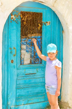 Kız mavi kapı çalıyor. Rethymno, Crete Yunanistan