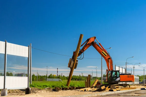 Graafmachine om te hameren stalen palen, weg van de bouw — Stockfoto