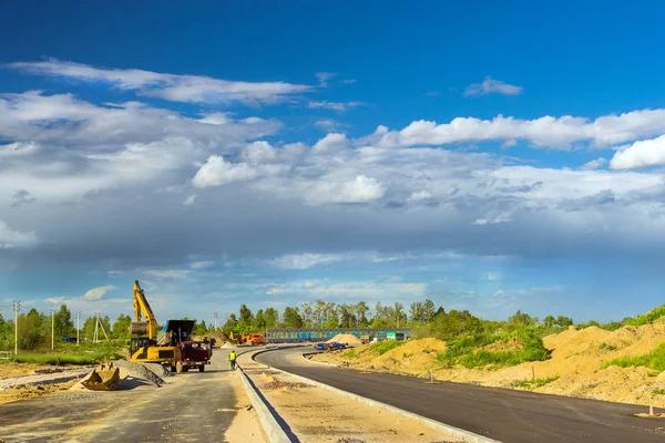 Excavator loads truck, construction bypass road