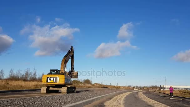 Escavatore cingolato con benna su strada di costruzione — Video Stock