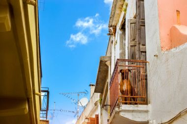 Kızıl saçlı, balkonda köpektir. Rethymno, Crete, Yunanistan