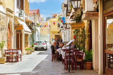 Turistler Girit, Yunanistan sokak Cafe menü okumak