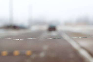 Araba cam ile çatlamak otomatik camında kırık. Bulanık gri zemin taşıma yol arka planda
