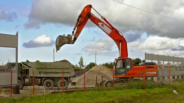 Le seau d'excavatrice charge le camion lourd avec le sol — Video