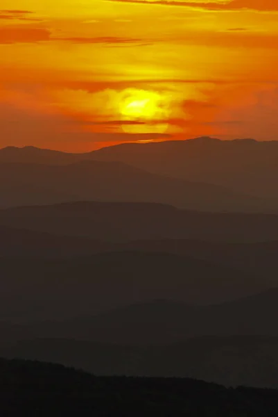 Paysage montagneux au coucher du soleil. Vue imprenable depuis le sommet de la montagne sur les rochers, les nuages bas, le ciel bleu et la mer le soir. Fond naturel coloré . — Photo