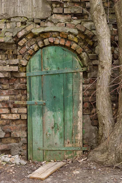 La vieille porte en bois sur le mur en ruine . — Photo