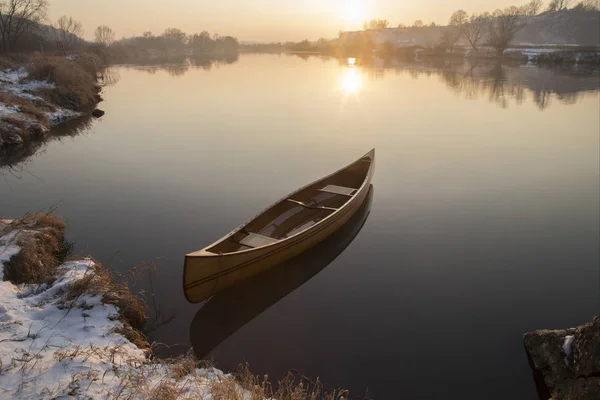 New Canoe floating on the calm water in winter sunset — Stock Photo, Image