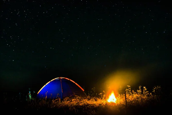 Night camping. campfire near illuminated tent under amazing nigh — Stock Photo, Image