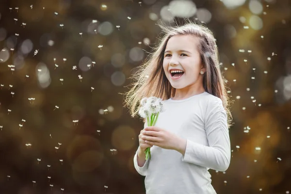 Κοριτσάκι μυρίζοντας μια λευκή πικραλίδες στο πάρκο φθινόπωρο Φωτογραφία Αρχείου