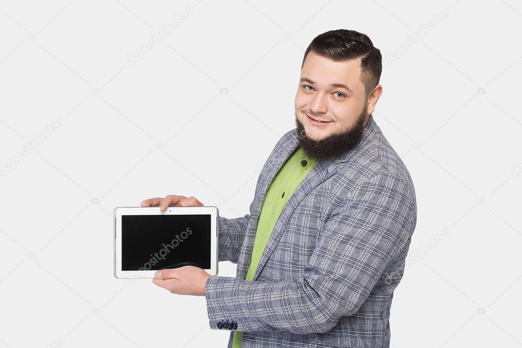 man with beard holds a tablet in hand
